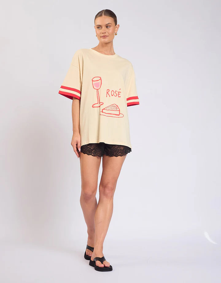 Easy, playful, and made for weekends — the Rosè All Day Tee is your go-to for relaxed styling with a touch of fun.
With its soft cream base, this tee is elevated by ribbed sleeve details that add structure, while the statement front and back prints bring personality from every angle. Designed in a relaxed fit, it’s the perfect throw-on-and-go piece that still feels effortlessly put together.