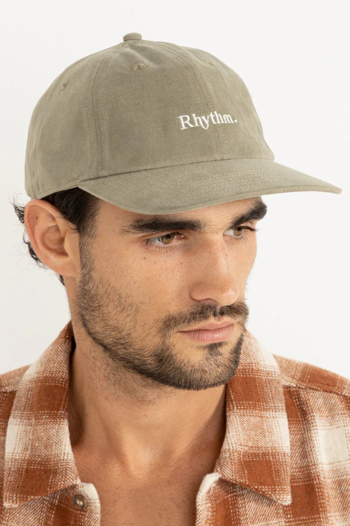 Embrace effortless style with the Essential Brushed Twill Cap in Sea Grass. This classic 6-panel cap boasts a curved peak and an embroidered logo, designed with embroidered eyelets for ventilation. The adjustable strap back closure provides a customizable fit, making it a versatile addition to your coastal wardrobe, finished with signature Rhythm labels and trims.