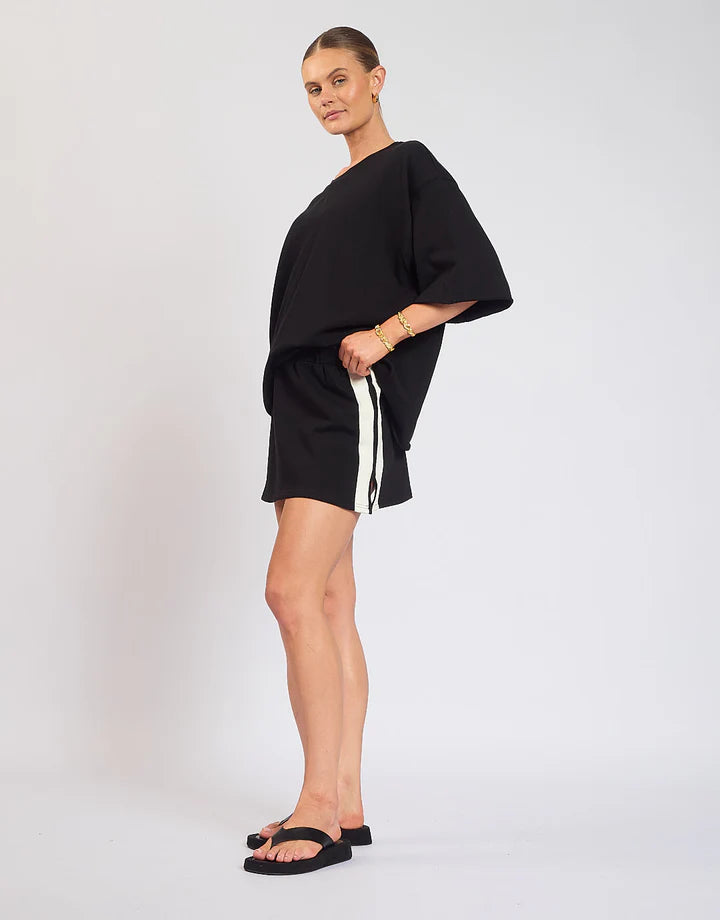 The Maya Mini Skirt is designed with a soft elastic waistband and detailed side stripes. Pair back with the Mason Tee in Black.