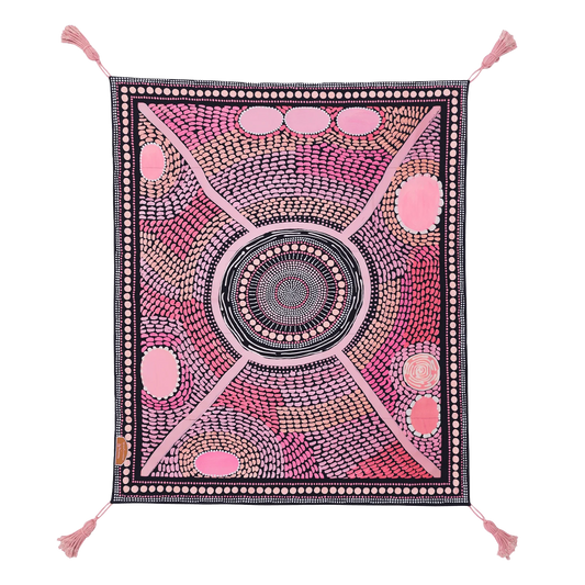 The first of our Artists Series, the Miinggi Jaanymili Picnic Rug features Indigenous artists duo Miimi and Jiinda’s artwork. The symbol in the middle represents a meeting place where people come together and connect. The circles around the outside are neighbouring tribes, friends and family that journey along the pathways, meeting in the middle to share stories, culture, food and celebrations.