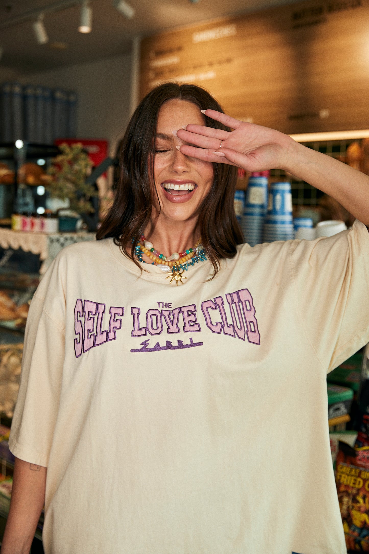 Step into unapologetic comfort and bold self-expression with The Very Oversized Self Love Club Tee in Off White. Crafted from premium, breathable cotton, this tee is designed with an ultra-relaxed, slouchy fit that drapes effortlessly – perfect for layering or rocking solo.
The front features the iconic SELF LOVE CLUB graphic in striking purple, a wearable reminder to put yourself first. On the back, a powerful pink statement – “The right people love the parts you try and hide” – serves as both a pep talk