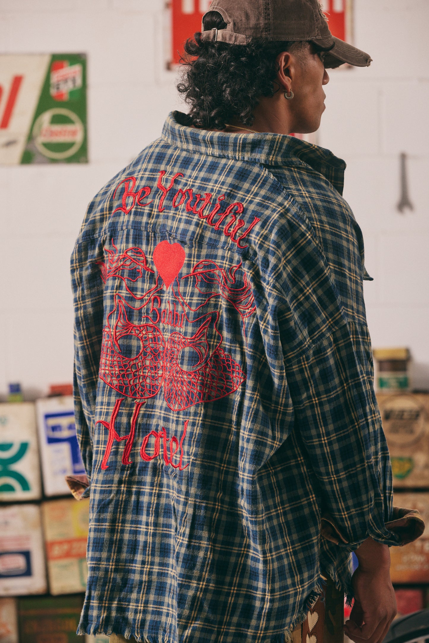Be Youtiful Sabbi Hotel Flannel Shirt
Turn heads and wear your heart on your back with the Be Youtiful Sabbi Hotel Flannel Shirt. This oversized, vintage-inspired button-up blends rugged charm with unapologetic attitude. Featuring bold red embroidery, twin masquerade masks, and the statement "Be Youtiful Babe Hotel" across the back, it's all about self-expression and standout style. Crafted from soft plaid cotton with raw edges for that perfectly worn-in feel — pair it with camo pants or your fave denim and