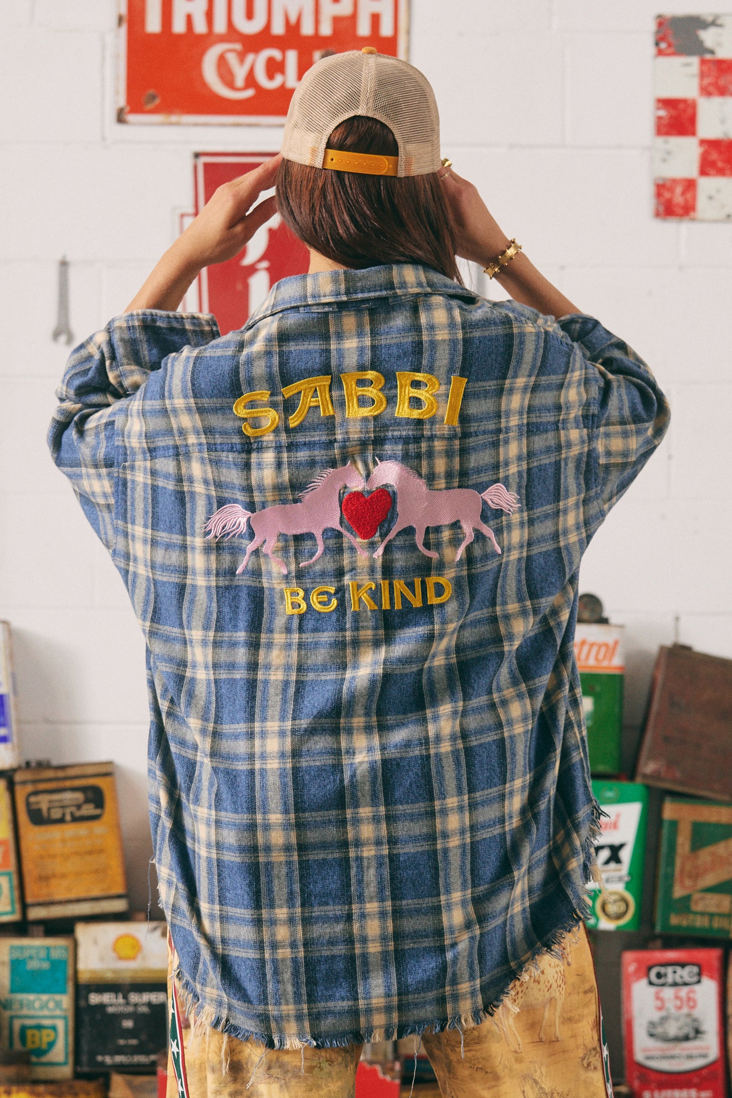 Grit, heart, and horsepower stitched into every thread. The Horse Power Flannel is a rebellious twist on the classic Western plaid — crafted for rule-breakers, wild riders, and soft-hearted renegades.
In a vintage-washed blue and sand check, this oversized shirt features bold yellow “HORSE POWER” embroidery down the sleeve and a custom SABBI “Be Kind” back patch with two galloping pink ponies and a red chenille heart — because strength and softness can ride side by side.