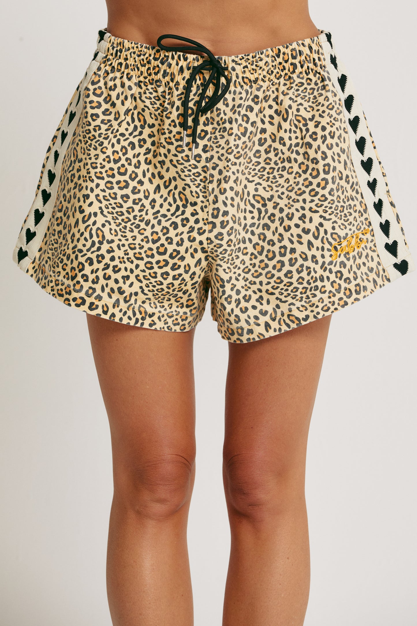 Unleash your wild side with The Mini Hearts Drill Shorts - Leopard, a bold mix of fierce and playful. Designed for all-day comfort with a street-chic edge, these shorts feature a striking leopard print that roars with attitude — balanced by signature contrast heart detailing down the sides for a touch of love-infused flair.