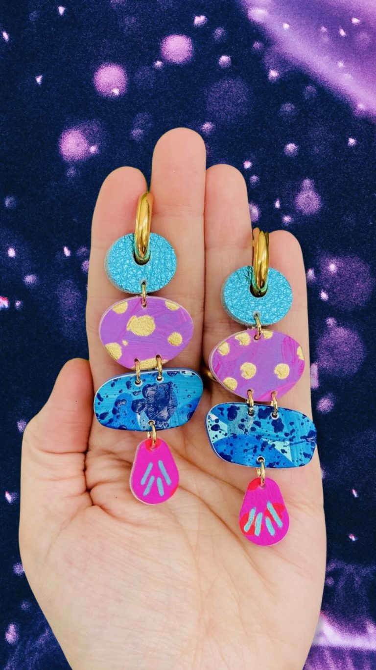 Featuring a complementary mix of metallics and hand painted leather beads in bright pinks, blues, purples and gold – set on golden stainless steel chunky hoops.