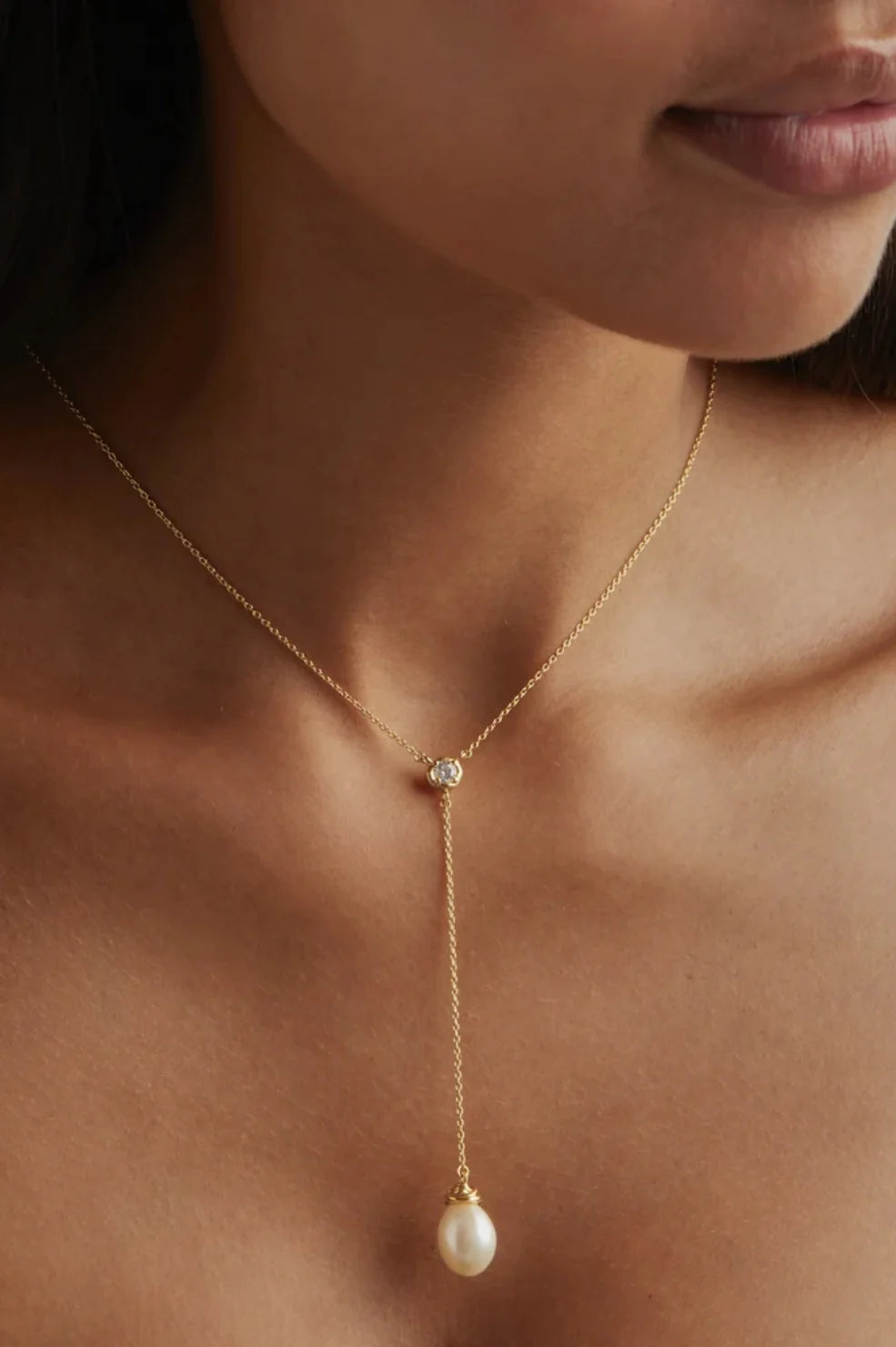 Harness the harmonious energy of natural pearl with the 18k Gold Vermeil Whispers of Tranquillity Pearl Lariat Necklace. This lariat-style necklace is designed with event dressing in mind, featuring a sparkling cubic zirconia and baroque freshwater pearl that sits delicately on the necklace. 