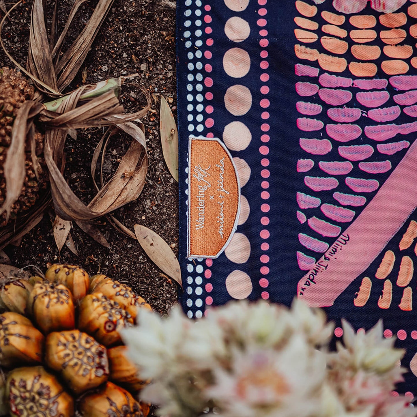 The first of our Artists Series, the Miinggi Jaanymili Picnic Rug features Indigenous artists duo Miimi and Jiinda’s artwork. The symbol in the middle represents a meeting place where people come together and connect. The circles around the outside are neighbouring tribes, friends and family that journey along the pathways, meeting in the middle to share stories, culture, food and celebrations.