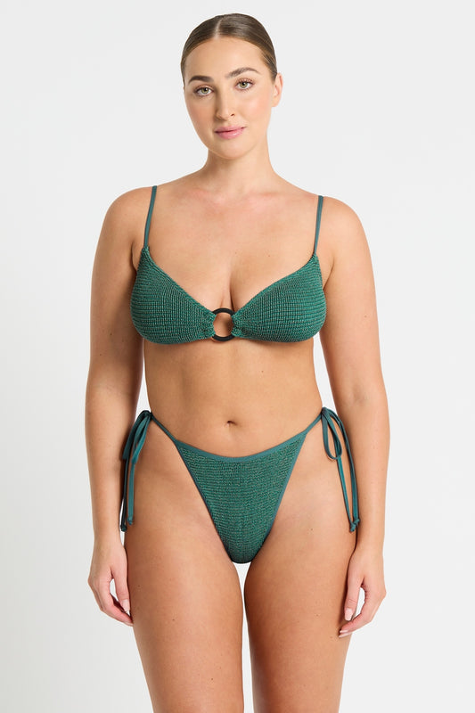 Dive into the shimmering waters with our Anisha Brief, a tie-side beauty offering mid coverage and adjustable ties. Made from The Authentic Crinkle™ fabric in enchanting Bottle Green Lurex, this swimwear style is the perfect blend of comfort and style, exuding a touch of luxury. Designed and handcrafted in Sydney, Australia, it's a must-have addition to your beach wardrobe.