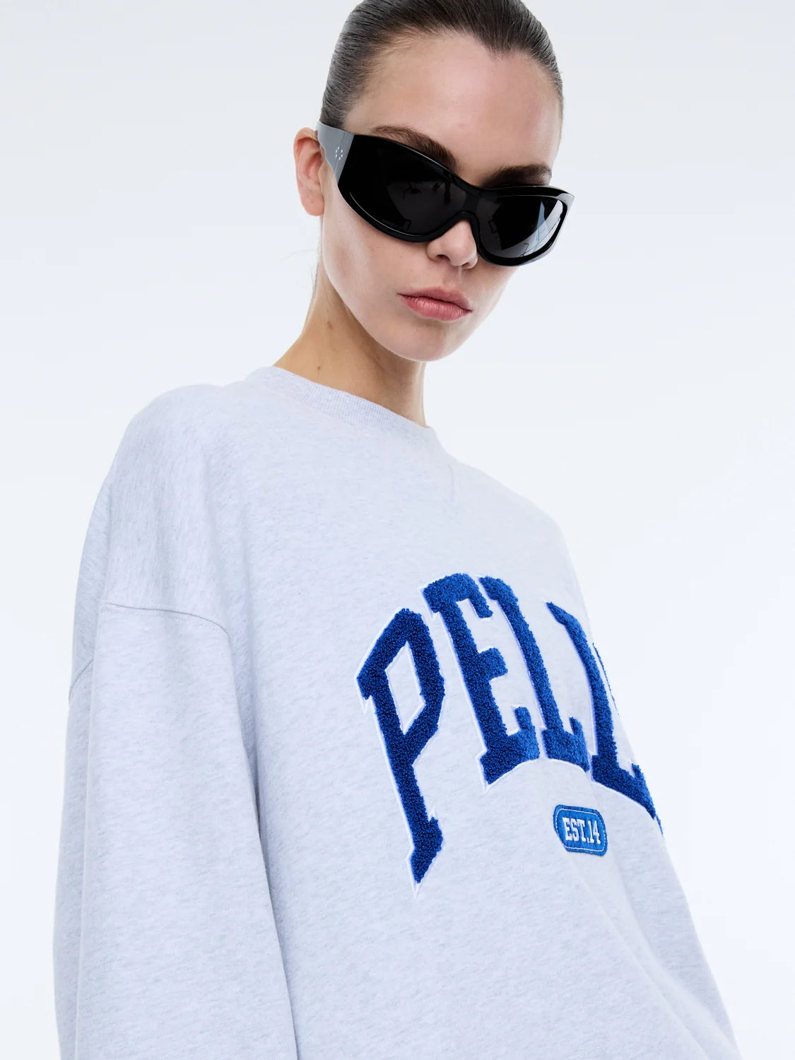 The Anniversary Sweatshirt is crafted from premium cotton terry, offering a soft yet durable texture. Featuring an oversized fit with a crew neckline, ribbed cuffs, and a ribbed neckband, it pairs comfort with elevated style. The exclusive Ena Pelly design is highlighted by a terry applique collegiate print, giving this sweatshirt its distinctive edge.