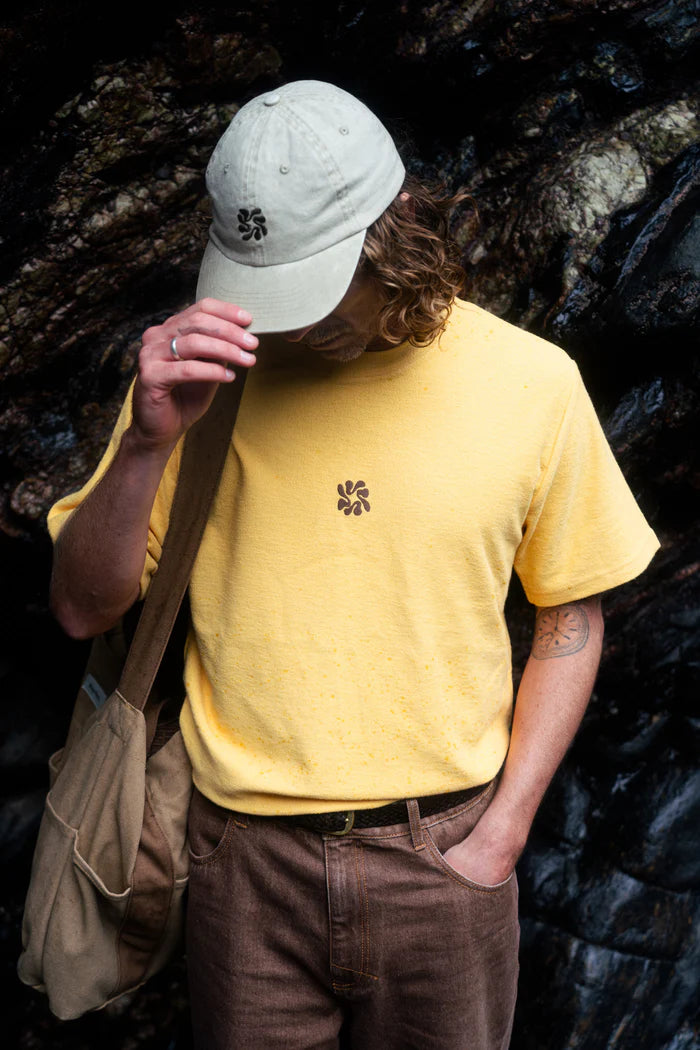The Traction Cap in Natural features lightweight pigment-dyed twill, a brass adjustable slider, and subtle center front embroidery, making it a timeless accessory.