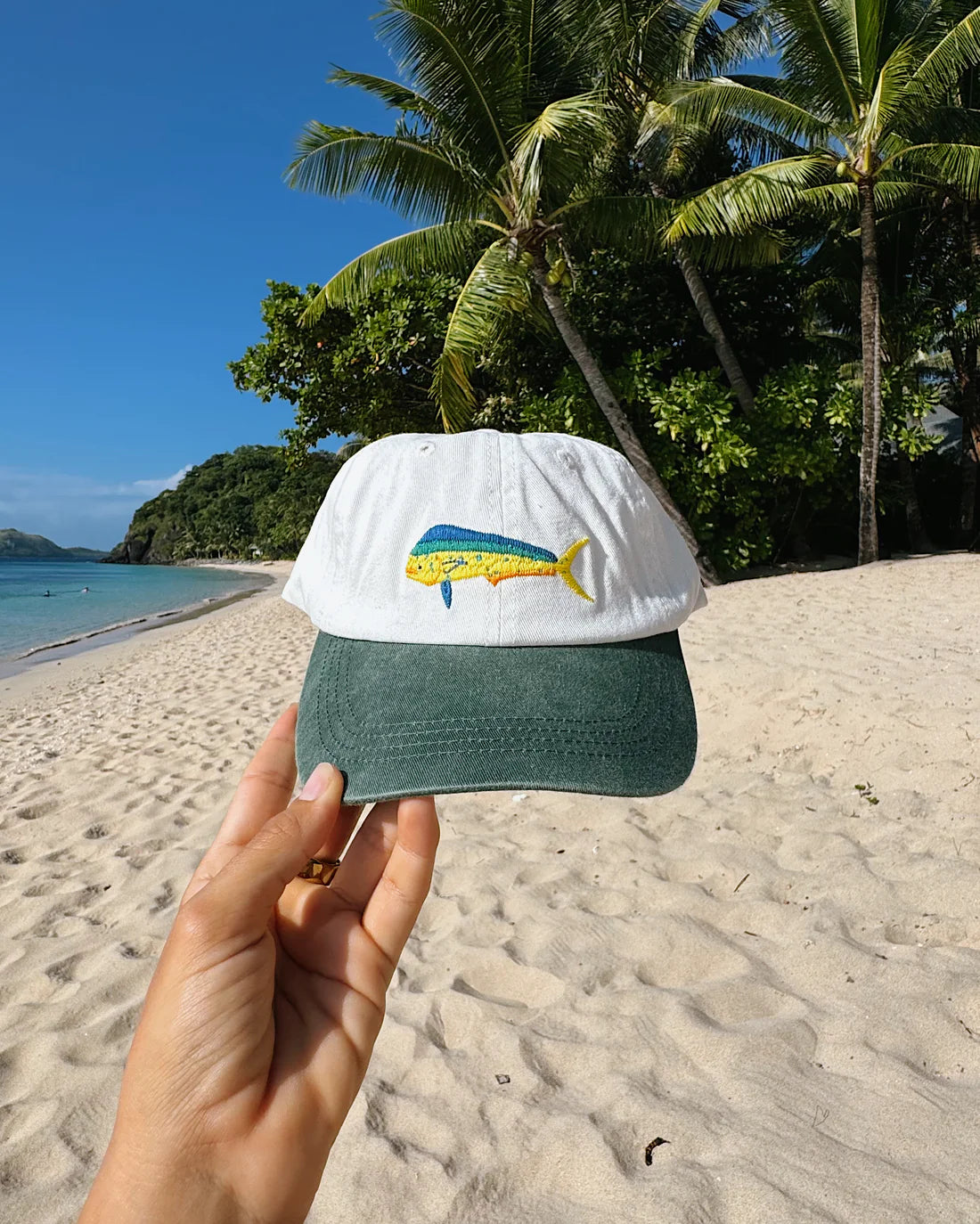 The Mahi Mahi (Coryphaena hippurus), also known as dolphinfish, dorado, or mahi-mahi, is the ultimate symbol of tropical waters and offshore adventures. This cap, with its bold two-tone colour-way of green and white, captures the vibrancy of this striking fish, from its iridescent blues to its golden hues.