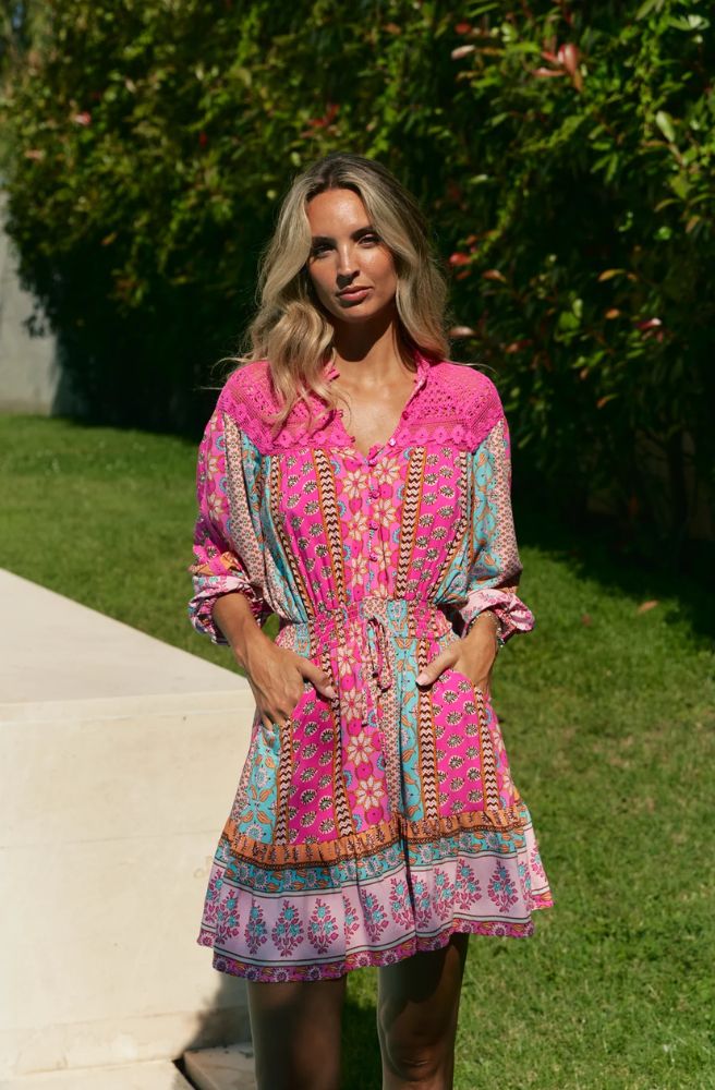 Feminine, vibrant, and effortlessly chic – the Cedella Print Olivia Mini Lace Dress is your go-to for sunshine days and balmy evenings. Designed in a flattering mini length, this dress features a striking mix of bold pinks, turquoise, and warm earthy tones in Jaase’s signature bohemian print.