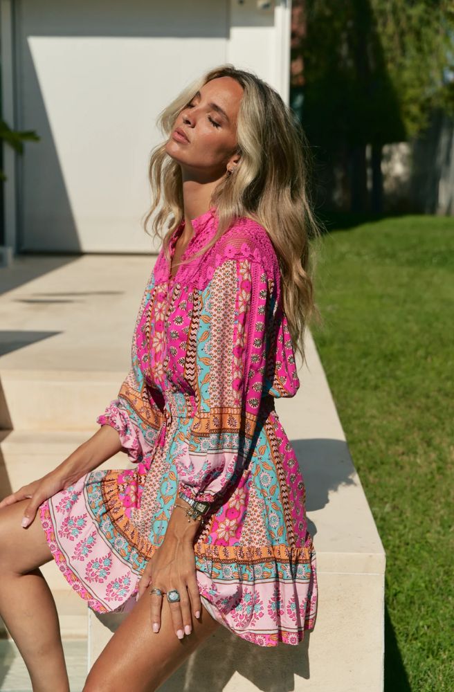 Feminine, vibrant, and effortlessly chic – the Cedella Print Olivia Mini Lace Dress is your go-to for sunshine days and balmy evenings. Designed in a flattering mini length, this dress features a striking mix of bold pinks, turquoise, and warm earthy tones in Jaase’s signature bohemian print.