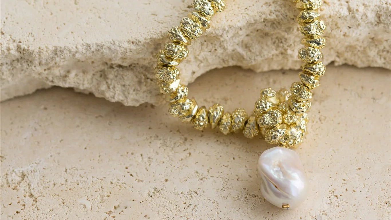 Indulge in luxury with JEWEL by Indigo and Wolfe, a 24Kt Gold Vermeil necklace featuring a stunning Baroque Pearl. This exclusive piece is a must have to elevate your outfit.