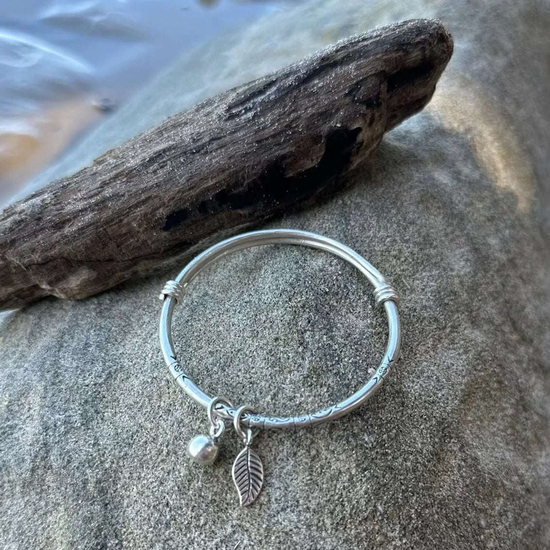 Let your child embrace our Kids Harmony Bangle, handcrafted and handstamped with Hilltribe Silver, these adjustable bracelets feature a gorgeous ball & leaf. Let the Kids Harmony Bangle be a symbol of joy and harmony, adding a delightful accent to your child's everyday style. This bangle is crafted from a soft metal that can be easily bent and adjusted to fit your wrist, please take care when wearing your treasured bangle. 