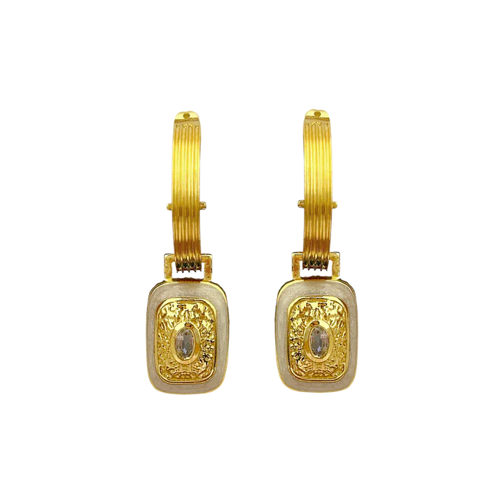 The Mara's are the epitome of classic style with a fabulous yet playful twist. They're beautiful, chic, and oh-so sassy… Crafted on a chunky fluted hoop, they feature a unique rectangle motif drop, combine with hammered gold texture, pearlescent enamel and eye-catching faceted Crystal Quartz gemstones. The Mara Earrings can be worn from day to night, with dazzling yet sophisticated flair that’s sure to turn heads. Enjoy the perfect balance of classic yet flirty with these