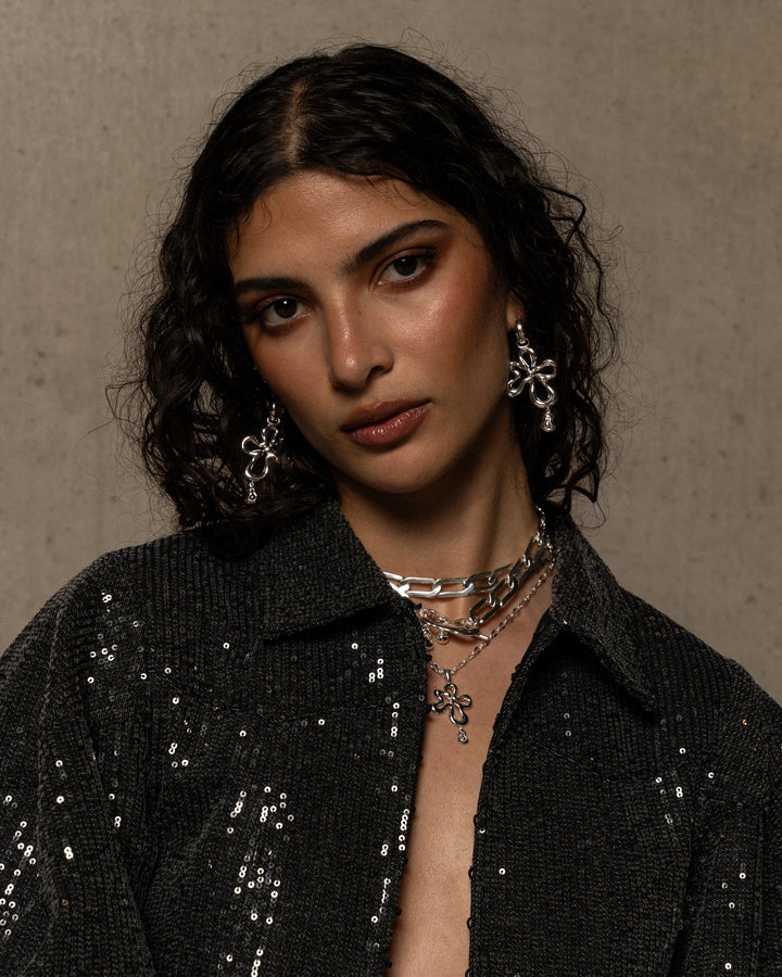 The DAHLIA Earrings in Silver evoke the playful side of nature’s elements, the ebbs and flows in water, the beautiful veining in untouched stone, the scalloping shores of the sea sides. The Dahlia boast a chic fluid motif suspended from a perfect and easy to wear mini hoop in a high polish finish. Sized to perfection suitable from day to night, these beauties are sure to become the favourites of the Ambrosia collection. Pair with the Maeve Necklace to create a gorgeous matching set.