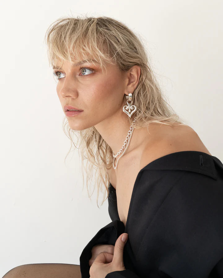 The Bella Earrings are now in silver! Everyone's favourite earrings look sleek, chic & stunning with the timeless Silver hoop and curved heart-shaped pendant accented with a petite pearl. This sophisticated and stylish statement style provides a perfect touch of chic fun to any outfit. A classic design that will pair with almost anything, these earrings will quickly become one of your go-to accessories.