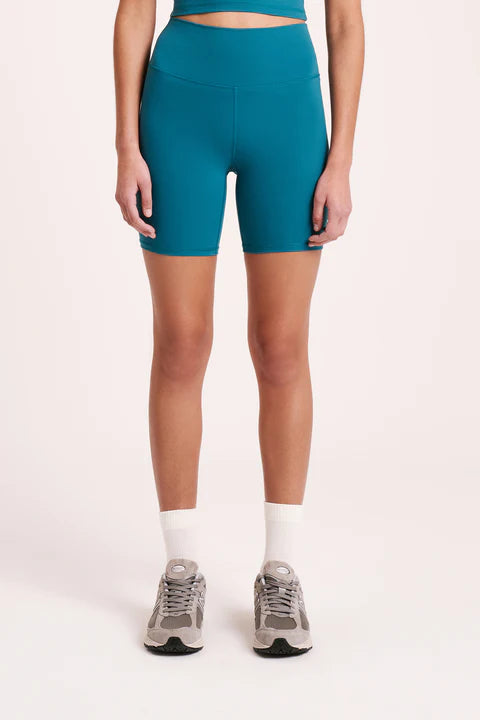 The Nude Active Bike short is made from a recycled performance fabrication with a matte, velvety finish. This fabric has 4-way stretch and has been designed to sculpt and smooth whilst providing full coverage and support for low-impact activities. Silhouette is form-fitting and high waisted with length finishing mid-thigh. Features include a double layer high rise waist, our signature nl. branded logo and a hidden waistband pocket at the centre back.