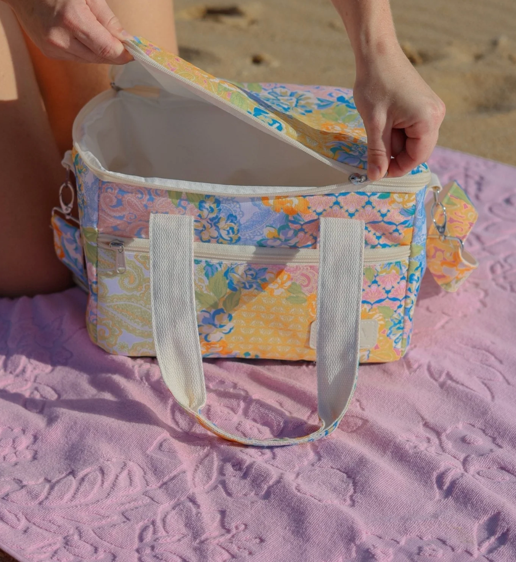 The Gardenia small cooler bag has a vibrant patchwork print of bohemian motifs and romantic florals. With insulation for freshness and easy to wipe-clean, Gardenia makes practical more playful. Spacious and versatile, it’s designed for picnics, beach days and weekend adventures.
- Premium and durable recycled polyester fabric made from plastic bottles
- W30 x D20 x H20cm (12L)
- Insulated internal lining
- Seek sun protection with a matching beach