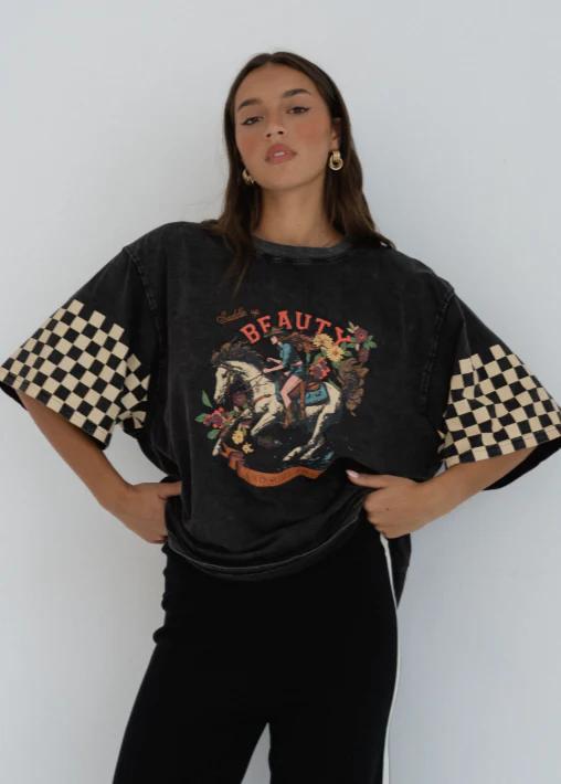 Black Beauty Tee
Make a bold statement with the Black Beauty Tee — featuring a vintage-inspired graphic print and edgy checkerboard sleeve details. This oversized, washed black tee blends comfort and street-style effortlessly, perfect for laid-back days or dressing up with your favorite accessories.