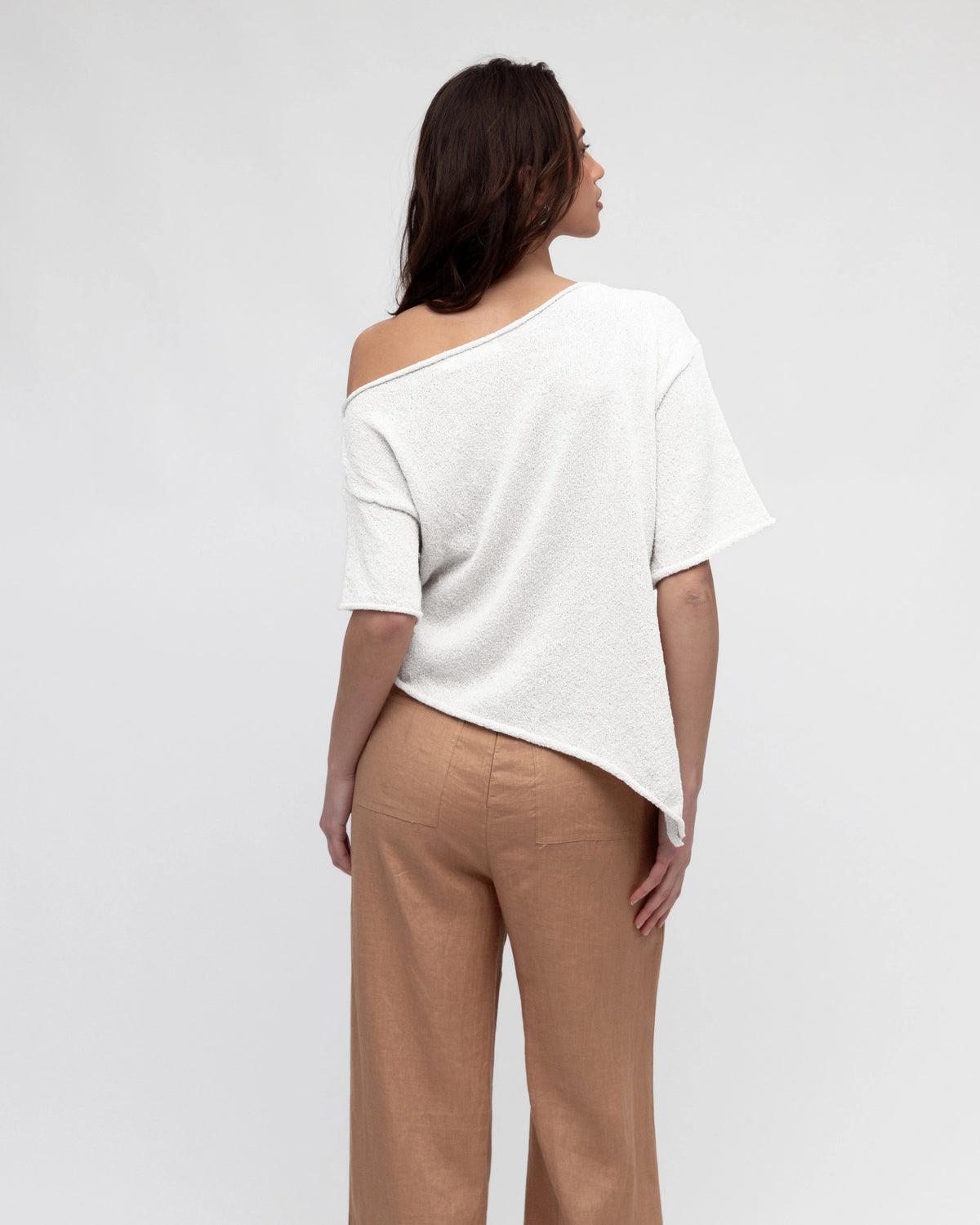 Effortless style meets everyday comfort. The Asy Bounce Knit Top is designed with a relaxed drape and an asymmetrical hemline, giving it a modern edge. Crafted from a soft textured knit, it features a wide neckline that can be styled off-the-shoulder for an easy, laid-back vibe. Perfect for pairing with tailored pants, denim, or skirts, this versatile piece moves seamlessly from casual days to elevated evenings.