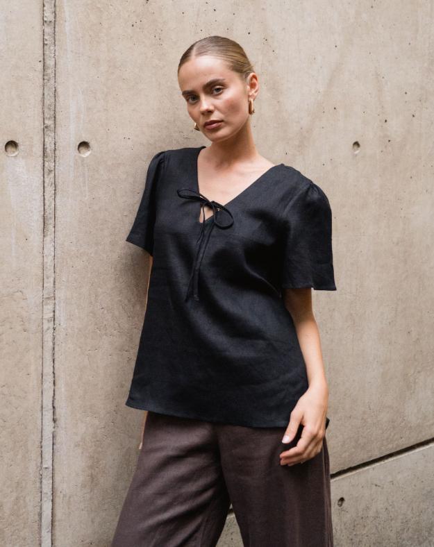 The Delight Top - Black
The White Closet Black Linen Top combines comfort and chic with its breathable linen fabric and floaty sleeves. Its loose fit allows for a relaxed style, while the elegant front tie-up across the bust adds a feminine touch. Wear it loose for effortless ease or tuck it in to highlight your silhouette. This versatile top is perfect for elevating your everyday look with understated sophistication.