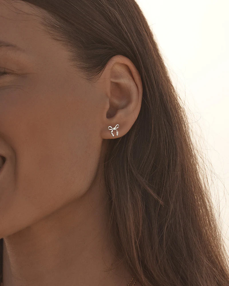 By Charlotte - The Forever More Bow Stud Earrings are a playful and delicate ode to love and romance. This keepsake is a tangible expression of the saying "tied together", with the bows symbolising love, cherished bonds, and devotion.
Sterling Silver: 92.5% pure silver and 7.5% alloy.
Delicate bow design set with a sparkling cubic zirconia.
Sold as a pair.
9 x 8mm.
Polished finish. 
