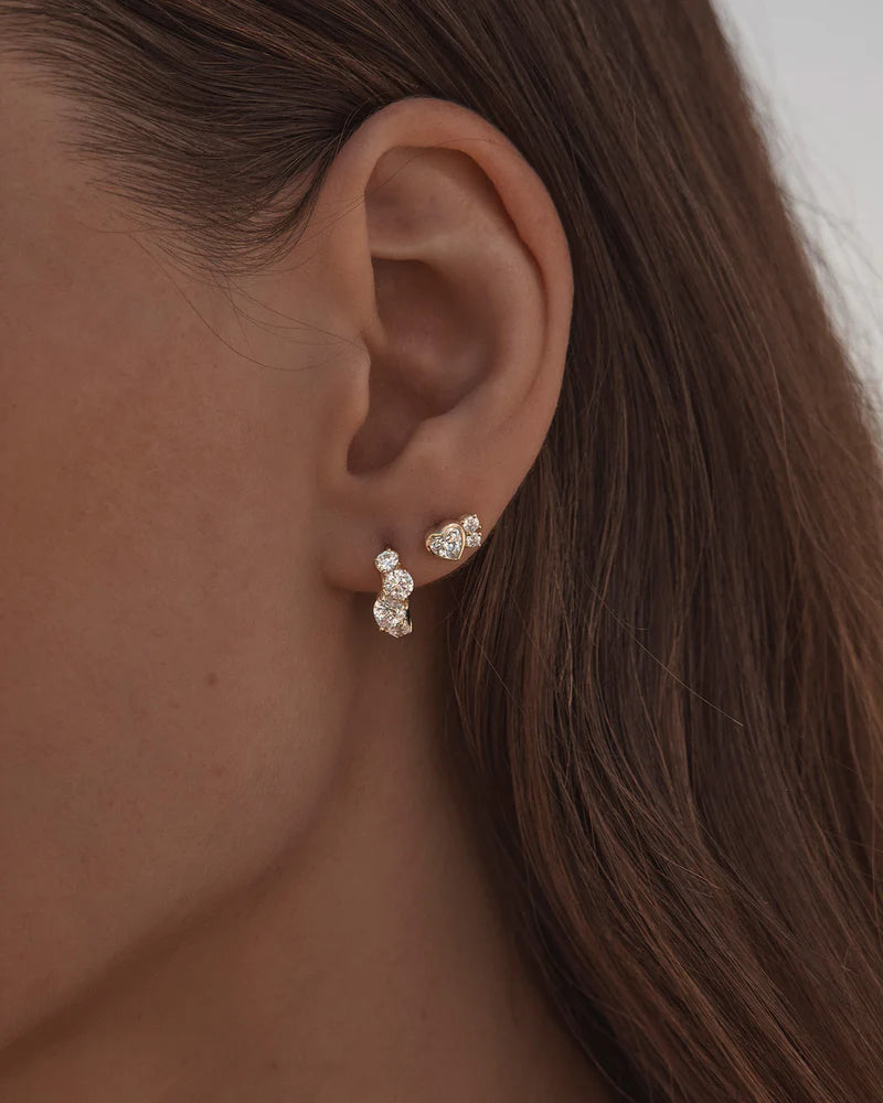 By Charlotte - The Dream Lover Huggies speak to the unspoken connections and the in-between moments of utmost intimacy. It is a celebration of connection and love at its most radiant and joyful.
18k Gold Vermeil: 2.5 microns of 18 carat gold coating a sterling silver base.
Features heart and round cut cubic zirconias in a claw setting.
Sold as a pair.
Hoop width: 3-4mm (varies).
Total length: 12mm.
Inner diameter: 9mm.
Polished finish.
Hinged mechanism