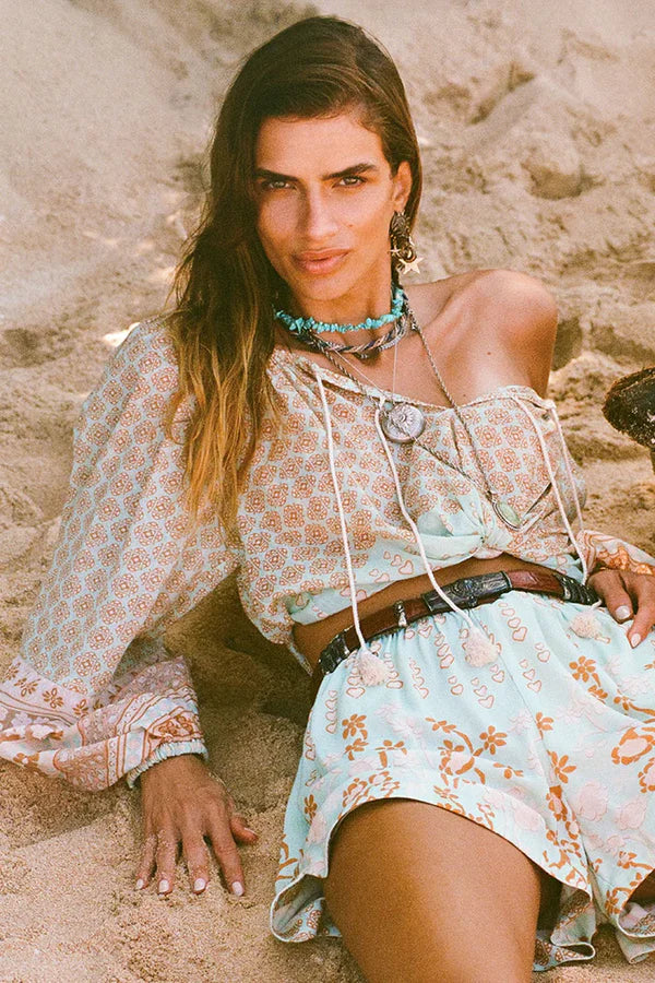 Our Sweet Nothings Blouse in Peppermint evokes the beauty of an ocean breeze. Four tassel-trimmed ties with bells adorn the neckline, allowing you to wear it open or tied for a look that’s both sweet and sophisticated