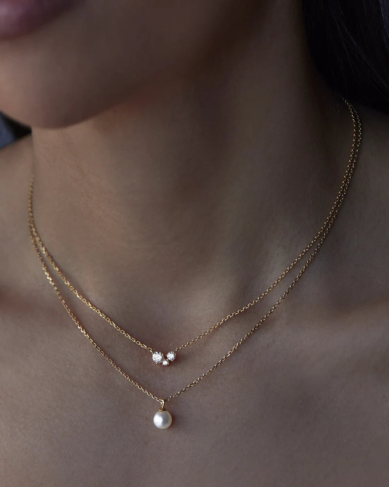 The Whispers of Love Necklace features a classic trio design with an asymmetrical twist with varying sizes of round-cut crystals. This piece is a visual poem to the simplicity of love - and all the quiet magic it holds. It’s classic and delicate design is the perfect subtle touch of sparkle for the bride looking to shine in her own light. 