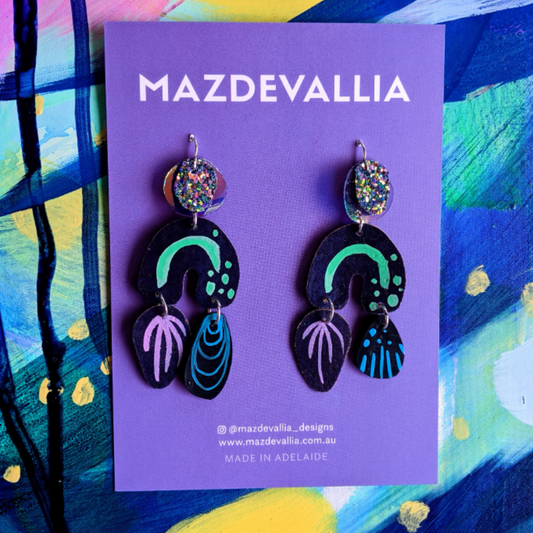 Orphelia Statement Earrings by Mazdevallia are made with hand painted cork leather, iridescent PVC, mermaid glitter fabric, hand painted abstract designs on hand cut polymer clay shapes.