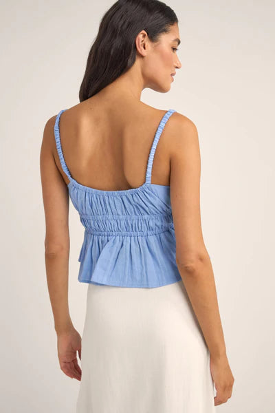 The Cornflower Tyler Baby Doll Top breezes into your wardrobe with a nod to carefree days by the sea. Its 100% cotton and textured checked fabric weave comfort and style into a baby doll silhouette that flutters with every coastal breeze. Featuring elasticated straps and under bust for a playful, gathered look, it's a sunlit melody of fabric and ocean air.