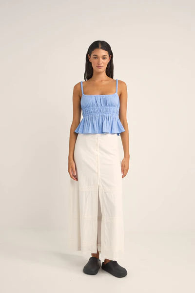 The Cornflower Tyler Baby Doll Top breezes into your wardrobe with a nod to carefree days by the sea. Its 100% cotton and textured checked fabric weave comfort and style into a baby doll silhouette that flutters with every coastal breeze. Featuring elasticated straps and under bust for a playful, gathered look, it's a sunlit melody of fabric and ocean air.