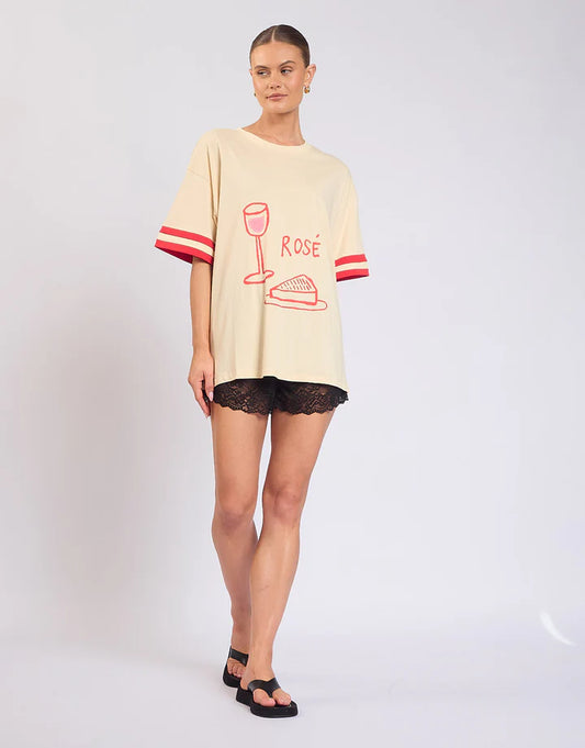 Easy, playful, and made for weekends — the Rosè All Day Tee is your go-to for relaxed styling with a touch of fun.

With its soft cream base, this tee is elevated by ribbed sleeve details that add structure, while the statement front and back prints bring personality from every angle. Designed in a relaxed fit, it’s the perfect throw-on-and-go piece that still feels effortlessly put together.