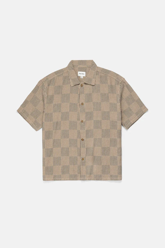Make a statement with the Tanner Check SS Shirt in Tobacco. This relaxed-fit shirt features a plastic button closure, a one-piece collar, and a straight hem, ensuring a polished look for casual outings. The Rhythm labels and trims complete this stylish piece, perfect for layering or wearing alone.

