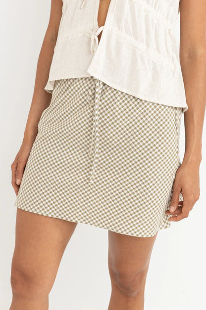 The Lola Check Bias Cut Mini Skirt in Olive adds a touch of charm to your wardrobe. This relaxed-fit mini skirt features an elastic waist with a self-drawcord for easy styling. The bias-cut design offers movement and flow, making it an effortless piece for any occasion.