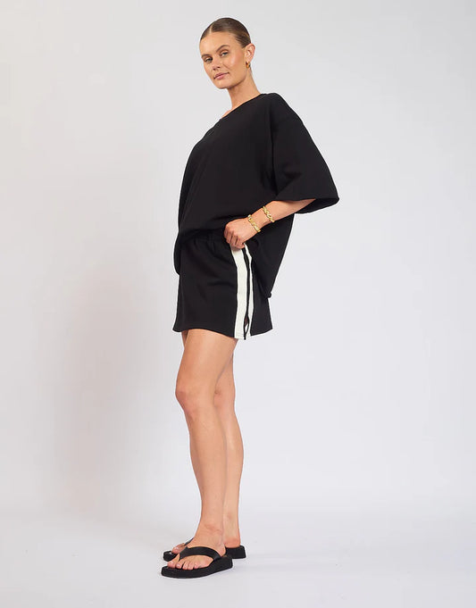 The Maya Mini Skirt is designed with a soft elastic waistband and detailed side stripes. Pair back with the Mason Tee in Black.