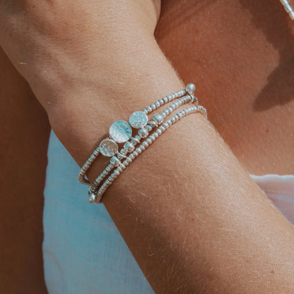 Wrap yourself in the serene beauty of our Oasis Wrap. Handcrafted with Hilltribe Silver beads and adorned with Hilltribe Silver charms, this wrap bracelet embodies tranquility and elegance. The sterling silver clasp and 7-link adjustable chain provide a secure and customizable fit on your wrist. Let the Oasis Wrap be a symbol of your inner sanctuary, bringing a sense of peace and serenity to your everyday style.