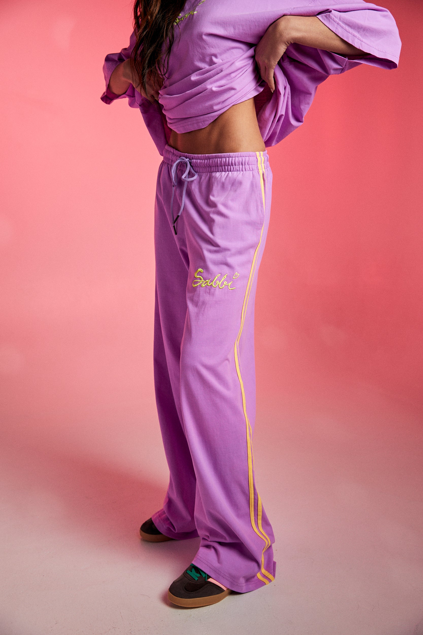Bright, bold, and unapologetically fun — meet The Chido Pants - Fluro Purple, your new go-to for laid-back luxe with a pop of attitude. Crafted from soft, breathable cotton, these relaxed-fit track pants bring comfort and colour in equal measure.