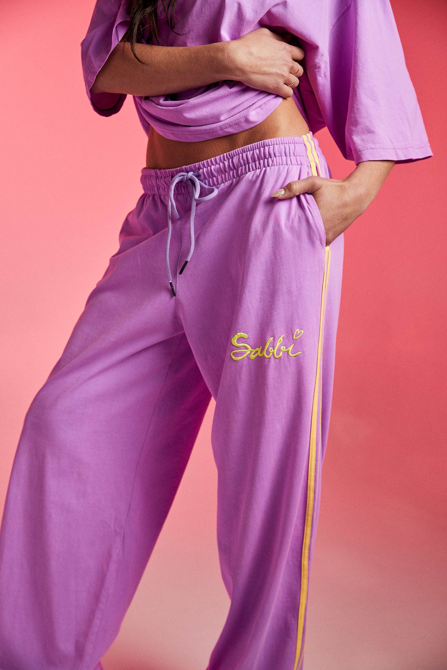 Bright, bold, and unapologetically fun — meet The Chido Pants - Fluro Purple, your new go-to for laid-back luxe with a pop of attitude. Crafted from soft, breathable cotton, these relaxed-fit track pants bring comfort and colour in equal measure.