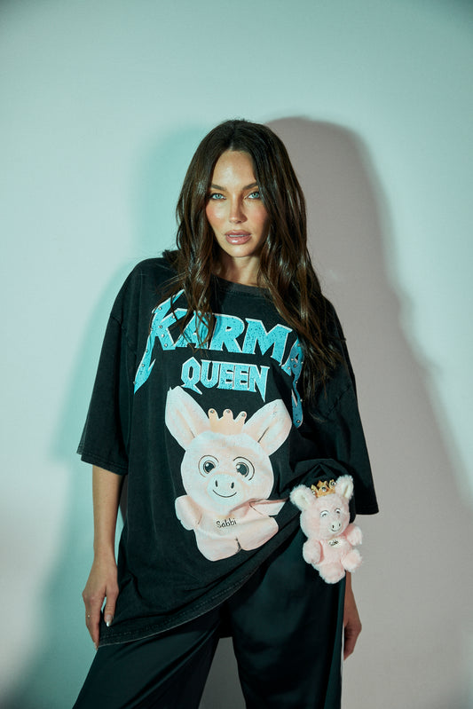 Rule your world in the Karma Queen Bling Tee – where sass meets sparkle. Crafted from premium black cotton with a vintage wash, this oversized tee features a bold graphic of the Karma Queen piglet, crowned in rhinestones for the perfect touch of bling. The statement “KARMA QUEEN” shimmers across the chest in studded detail, while the back reads “I SAW THAT – KARMA” as a cheeky reminder that nothing goes unnoticed.
