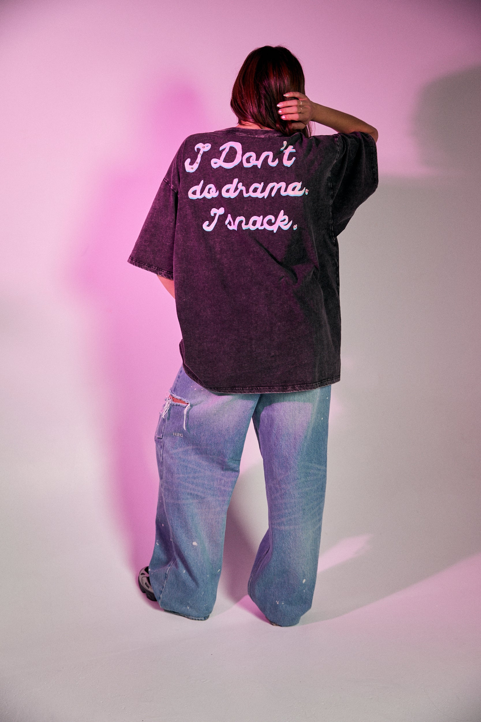 Keep it chill and playful with the No Drama Llama Bling Tee. Designed in a relaxed, oversized fit, this black vintage-wash tee is all about fun with its bold, sparkling graphic of a sassy llama framed by a dreamy heart. The rhinestone embellishments bring extra bling to your casual wardrobe, while the cheeky back print – “I Don’t Do Drama, I Snack” – seals the deal on your effortlessly cool vibe.
