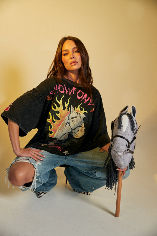 Keep it chill and playful with the No Drama Llama Bling Tee. Designed in a relaxed, oversized fit, this black vintage-wash tee is all about fun with its bold, sparkling graphic of a sassy llama framed by a dreamy heart. The rhinestone embellishments bring extra bling to your casual wardrobe, while the cheeky back print – “I Don’t Do Drama, I Snack” – seals the deal on your effortlessly cool vibe.