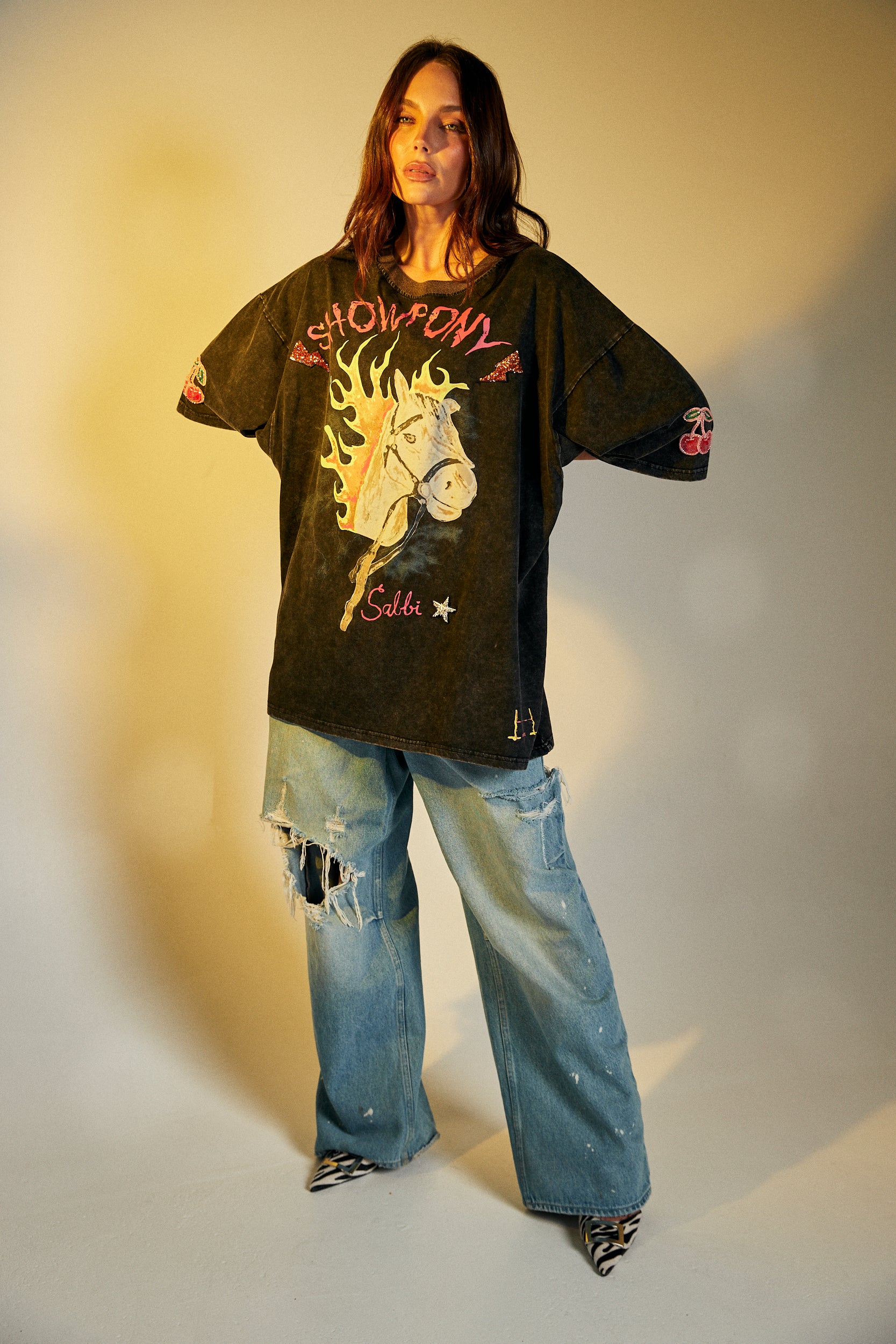 Keep it chill and playful with the No Drama Llama Bling Tee. Designed in a relaxed, oversized fit, this black vintage-wash tee is all about fun with its bold, sparkling graphic of a sassy llama framed by a dreamy heart. The rhinestone embellishments bring extra bling to your casual wardrobe, while the cheeky back print – “I Don’t Do Drama, I Snack” – seals the deal on your effortlessly cool vibe.