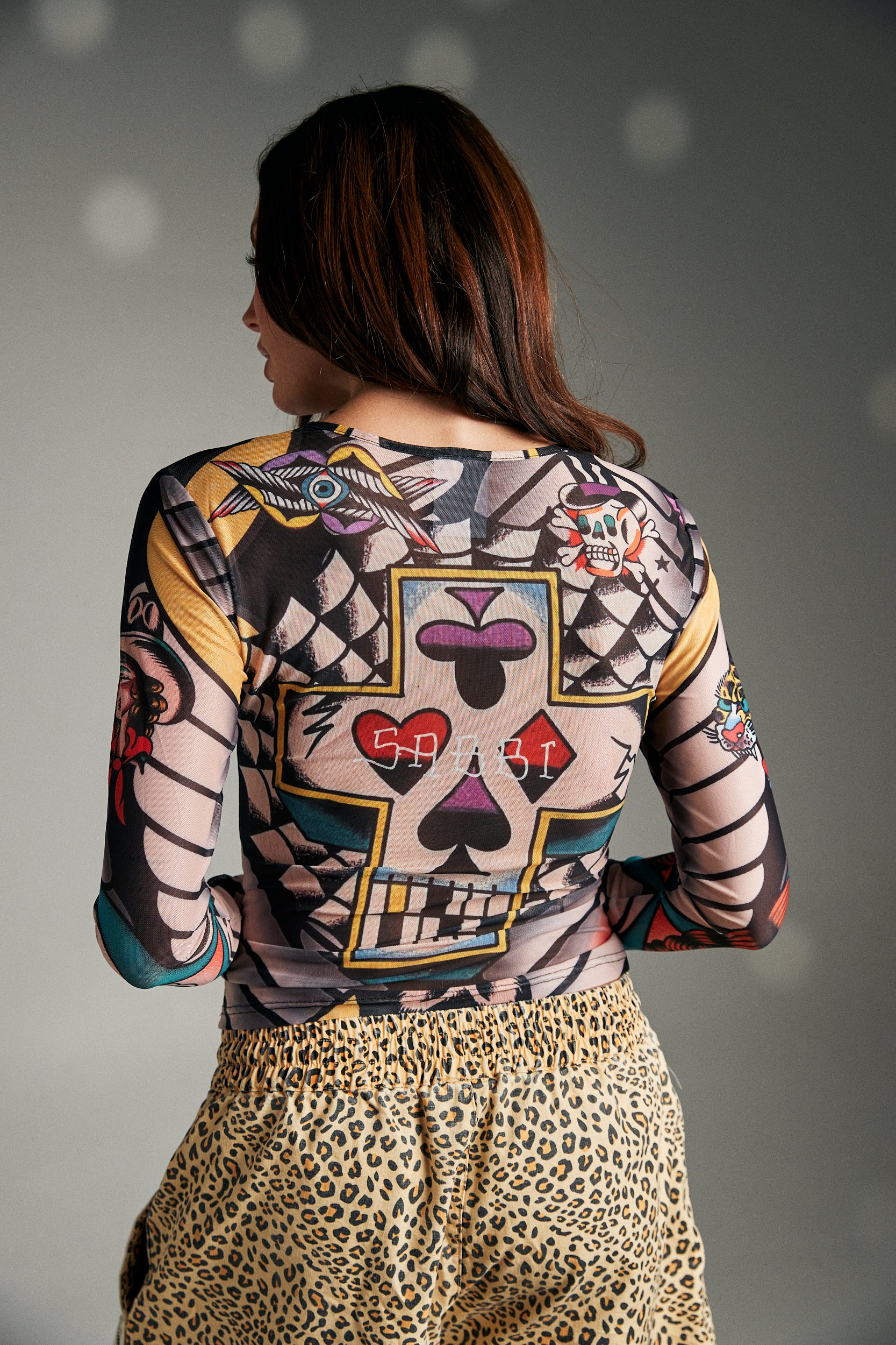 Make a bold statement with the Got Ink Mesh Top — a second-skin style designed for fearless self-expression. Crafted in sheer mesh, this long-sleeve top is covered in vibrant, tattoo-inspired graphics, from fierce tigers to retro motifs, giving you an all-over inked look without the commitment. The body-hugging fit and lightweight stretch fabric make it perfect for layering or wearing solo when you want all eyes on you.