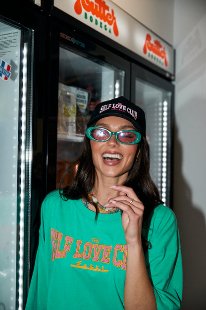 Top off your look with the ultimate dose of self-love energy. The Self Love Club Cap in Black is your go-to accessory for effortless cool and unapologetic confidence. Featuring bold embroidered “SELF LOVE CLUB” lettering in pink and white across the front, this classic curved-brim design is equal parts street style and statement piece.a

Crafted for comfort and everyday wear, it’s fully adjustable at the back for the perfect fit and includes a secret love note embroidered on the inside – “You are Magic – Lo