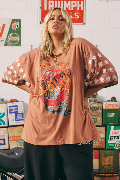 The Dream Big Brenda Clay Tee

Make a statement without saying a word. The Dream Big Brenda Tee is a fearless fusion of vintage Americana and rebellious femme energy. Featuring a bold winged mermaid graphic emblazoned across the chest and “MERMAID MOTORCYCLE CO” on the back, this oversized tee celebrates every wild-hearted wanderer who dreams big and rides free.