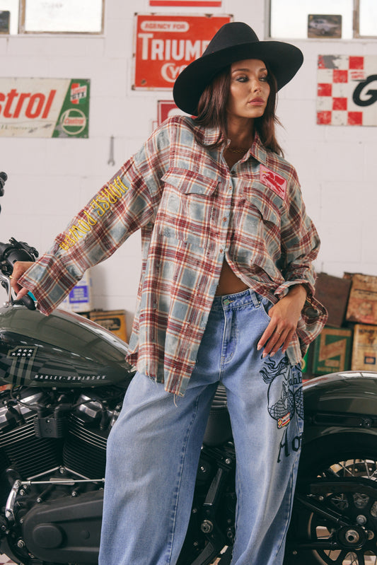 The Horse Power Distressed Flannel Shirt – Burgundy

Where grit meets kindness. The Horse Power Distressed Flannel in Burgundy is your go-to layer for laid-back rebellion. With a sun-faded, vintage-inspired burgundy and blue check, this oversized shirt brings serious attitude with a soft side.

The back steals the show with SABBI’s signature embroidered pink ponies, chenille red heart, and “BE KIND” slogan — a sweet reminder stitched into a tough-as-nails piece. The right sleeve is embroidered with “HORSE P
