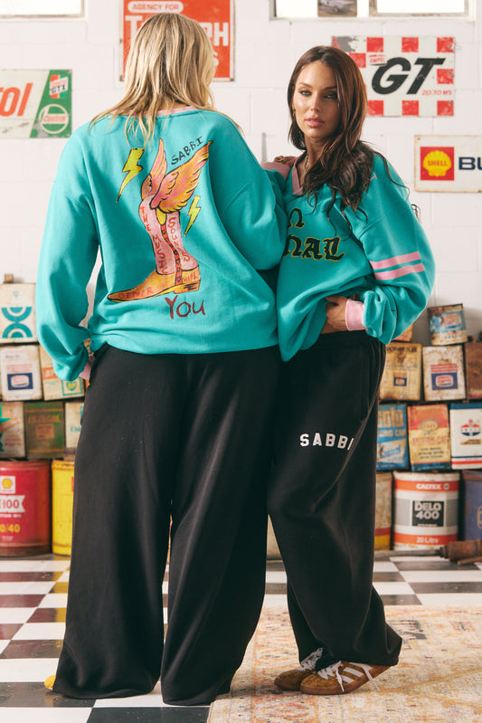The Born Original Tee – Teal &amp; Pink
Fuel your fire and wear your power proudly in the Born Original Tee – Teal &amp; Pink. This oversized, vintage-sport inspired tee features statement gothic lettering, contrast pink varsity stripes, and bold yellow lightning bolts for an electrifying twist. The teal cotton base brings a fresh pop of colour, while the custom artwork on the back — winged boots and affirmations — reminds you that the world is better with your original energy. Equal parts comfy and cool, t